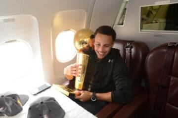 Los campeones de la NBA disfrutaron del viaje de vuelta a Oakland sin perder de vista el preciado trofeo Larry O'Brien. Stephen Curry.