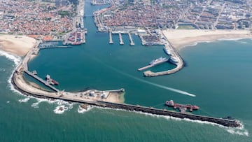 El puerto de Matosinhos (Portugal) visto desde el aire sobre el agua del mar, con el rompeolas en primer plano y la ciudad al fondo. La playa de Matosinhos queda a la derecha. 