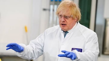 A handout image released by 10 Downing Street, shows Britain's Prime Minister Boris Johnson wearing PPE (personal protective equipment), including eye protection and gloves, during his visit to the UK Biocentre in Milton Keynes, north of London, on J