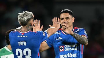 Cruz Azul's Uruguayan forward #21 Gabriel Fernandez celebrates after scoring his team's third goal with teammate Cruz Azul's Argentine defender #33 Gonzalo Piovi during the Liga MX Apertura football tournament match between Cruz Azul and santos at the Olimpico Universitario Stadium in Mexico City on August 16, 2025. (Photo by YURI CORTEZ / AFP)