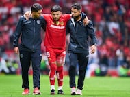 Los médicos ayudan a Alexis Vega a salir de la cancha después de su lesión.