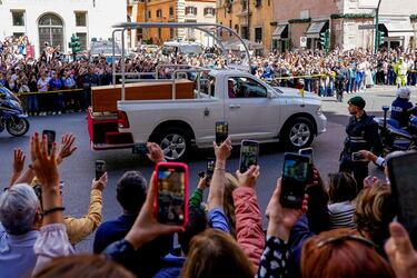 La gente reacciona mientras un coche fúnebre con el féretro del Papa Francisco recorre la calle Corso Vittorio el día de su funeral, en Roma, Italia, el 26 de abril de 2025.