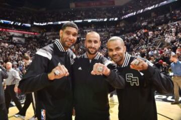 En 2014 Tim Duncan #21, Marco Belinelli #3 y Tony Parker #9 de los San Antonio Spurs enseñando sus anillos de campeones.