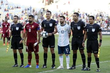 El árbitro colombiano Wilmar Roldán arropado por  los capitanes Tomás Rincón de Venezuela, Leo Messi de Argentina, el cuarto árbitro y los jueces de línea.