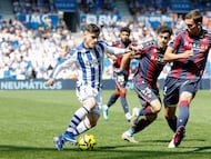 SAN SEBASTIÁN, 04/04/2026.- El futbolista de la Real Sociedad Ánder Barrenetxea (i) lucha por el balón con Manu Sánchez (c), del Levante UD, durante el partido de LaLiga EA Sports disputado este sábado en el Estadio de Anoeta de San Sebastián. EFE/Javier Etxezarreta