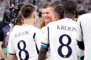 Toni Kroos, recibe el reconocimiento de los jugadores de ambos equipos y aficionados en el estadio Santiago Bernabéu. En la imagen, el futbolista alemán atraviesa con honores el pasillo formado por los conjuntos del Real Madrid y Betis.