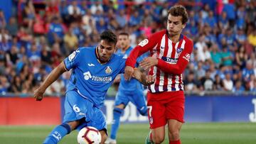 Cabrera despeja el bal&oacute;n ante Griezmann en el Getafe-Atl&eacute;tico.