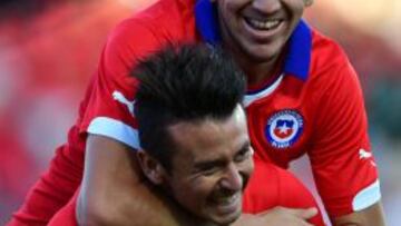 Chilean footballer Roberto Gutierrez (L) celebrates with Diego Valdez (R) after scoring against the US during a friendly football match at the El Teniente Stadium in Rancagua, some 80 km south of Santiago, on January 28, 2015. AFP PHOTO/MARTIN BERNETTI