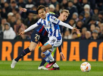 Takefusa Kubo y Frenkie de Jong, con los brazos muy abiertos, observan atentamente al balón.