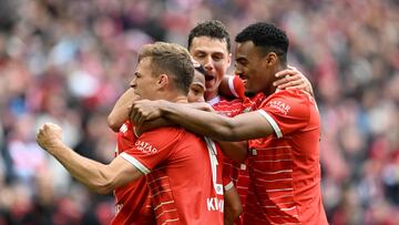 Bayern Munich's German midfielder Serge Gnabry (2nd L, hidden) is congratulated by Bayern Munich's German midfielder Joshua Kimmich (L), Bayern Munich's French defender Benjamin Pavard (2nd R) and Bayern Munich's Dutch midfielder Ryan Gravenberch (R) after he scored the 4-0 goal during the German first division Bundesliga football match between FC Bayern Munich and Schalke 04 in Munich, southern Germany, on May 13, 2023. (Photo by Christof STACHE / AFP) / DFL REGULATIONS PROHIBIT ANY USE OF PHOTOGRAPHS AS IMAGE SEQUENCES AND/OR QUASI-VIDEO