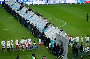 A la salida de los jugadores comenzó la performance en el que se simuló la caída del falso muro.