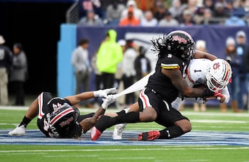 Payton Thorne, quarterback de los Auburn Tigers, sufre el intento de detención con todas las armas posibles, por lo civil o lo criminal, al alcance de los defensores de los Maryland Terrapins, el linebacker Caleb Wheatland  (dorsal 44) y el lineman Quashon Fuller (5) durante la primera parte del partido en el Nissan Stadium.