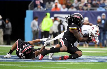 Payton Thorne, quarterback de los Auburn Tigers, sufre el intento de detención con todas las armas posibles, por lo civil o lo criminal, al alcance de los defensores de los Maryland Terrapins, el linebacker Caleb Wheatland  (dorsal 44) y el lineman Quashon Fuller (5) durante la primera parte del partido en el Nissan Stadium.