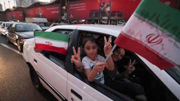 Iranians celebrate the victory of their team against Wales in the streets of Tehran.