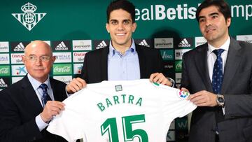 El central Marc Bartra, procedente del Borussia Dortmund alemán, sujeta la camiseta que con su nombre junto al vicepresidente, Lorenzo Serra Ferrer (i), y el presidente del club bético Ángel Haro, durante su presentación hoy tr