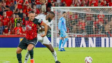 PALMA, 18/08/2024.- El defensa alemán del Real Madrid Antonio Rüdiger (d) lucha con Vedat Muriqi, del RCD Mallorca, durante el partido de LaLiga entre el RCD Mallorca y el Real Madrid, este domingo en el estadio de Son Moix, en Palma. EFE/CATI CLADERA