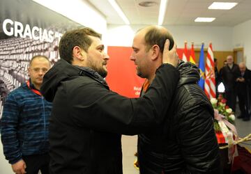 Uno de los hijos de Quini recibe el pésame de un compañero de la prensa.