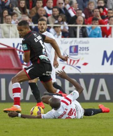 El centrocampista camerunés del Sevilla Stephane Mbia (d) pelea un balón con el delantero marroquí del granada Youssef El-Arabi, durante el partido de la decimotercera jornada de la liga en Primera División que se disputa esta tarde en el estadio Ramón Sánchez Pizjuan.