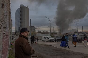 Peatones caminan en un mercadillo mientras el humo se eleva a lo lejos tras el ataque con misiles rusos en Kiev el 6 de abril de 2025, en medio de la invasión rusa de Ucrania. El alcalde de Kiev declaró que la ciudad fue atacada con misiles el 6 de abril de 2025, con explosiones en la capital ucraniana, dos días después de que un misil ruso matara a 18 personas en la ciudad natal del presidente de Ucrania.