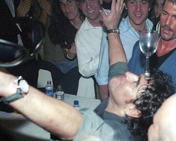 La leyenda del fútbol argentino Diego Maradona baila con un vaso en la cabeza mientras celebra su 40 cumpleaños en una discoteca en Buenos Aires el 31 de octubre de 2000.