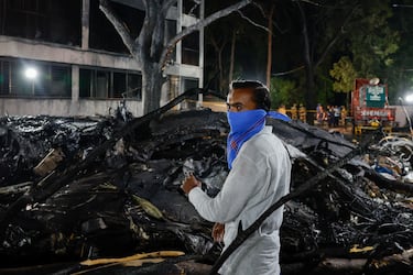 Una persona permanece junto a los restos de un avión de Air India, con destino al aeropuerto londinense de Gatwick, que se estrelló durante el despegue desde un aeropuerto en Ahmedabad, India.