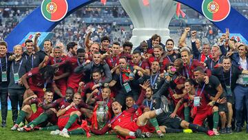 Portugal&#039;s forward Cristiano Ronaldo (C) and teammates pose with the trophy as they celebrate after beating France during the Euro 2016 final football match at the Stade de France in Saint-Denis, north of Paris, on July 10, 2016. / AFP PHOTO / Valery