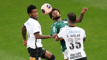 Gil (i) y Danilo Avelar (d) de Corinthians disputan balón con Luis Adriano de Palmeiras este miércoles durante el partido de ida de la final del Campeonato Paulista entre Corinthians y Palmeiras.