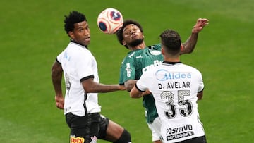 Gil (i) y Danilo Avelar (d) de Corinthians disputan bal&oacute;n con Luis Adriano de Palmeiras este mi&eacute;rcoles durante el partido de ida de la final del Campeonato Paulista entre Corinthians y Palmeiras.