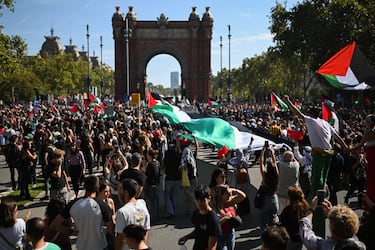 Decenas de manifestantes extienden una bandera de Palestina durante una manifestación en apoyo a Palestina.