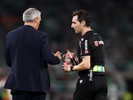 El árbitro Ricardo De Burgos recoge las botellas lanzadas al terreno de juego tras el segundo gol del Sevilla FC.