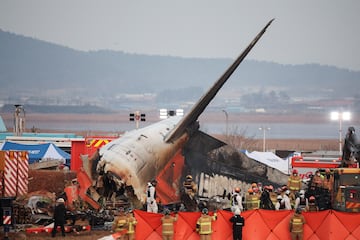 Los equipos de rescate participan en una operación de salvamento en el lugar donde el avión se estrelló después de salirse de la pista en el Aeropuerto Internacional de Muan, en Muan, Corea del Sur.