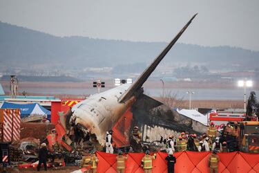 Los equipos de rescate participan en una operación de salvamento en el lugar donde el avión se estrelló después de salirse de la pista en el Aeropuerto Internacional de Muan, en Muan, Corea del Sur.