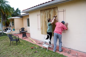 Sofia Andreeva y su tío Ivaylo Kanchev tapian su casa antes de la llegada del huracán Milton a San Petersburgo, Florida.