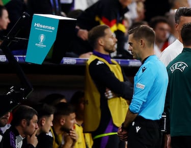 El árbitro Clement Turpin revisa en el monitor del VAR la acción del defensa escocés con Ilkay Gündogan.