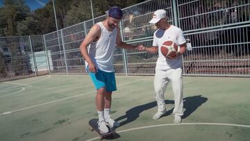 El jugador de baloncesto del Real Madrid Sergio Llull patinando cogido de la mano del skater Danny León, que tiene un balón en la mano, en una pista de basket de Madrid.