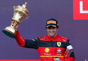 Carlos Sainz levantando su primer trofeo ganador en la cima del podio de Silverstone.