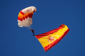 Un paracaidista lleva una bandera española durante el desfile militar del feriado nacional conocido como "Día de la Hispanidad" en Madrid. Este año, es el primero en el que una mujer despliega la bandera en paracaídas.