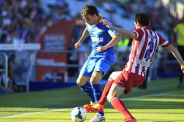El centrocampista del Getafe Pedro León (i) con el balón ante el defensa uruguayo del Atlético de Madrid Diego Godín (d), en el partido de la trigésima tercera jornada de liga de Primera División disputado esta tarde en el Coliseo Alfonso Pérez de Getafe. 