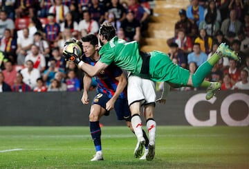 Stole Dimitrievski detiene el balón con la oposición de Robert Lewandowski y su compañero de quipo, Iván Balliu.