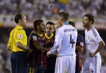 Mateu Lahoz observa la discusión de Neymar y Coentrao, fuera de imágen, mientras un mechero lanzado desde la grada queda suspendido en el aire.