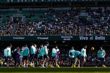 Los jugadores del Real Betis Balompié se entrenan ante la mirada de sus aficionados.