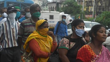 Commuters stand in a queue waiting to board government buses to go back home, as a two-day lockdown is imposed every week across West Bengal state starting from July 23 to fight against the surge in COVID-19 coronavirus cases, in Kolkata on July 22, 2020.