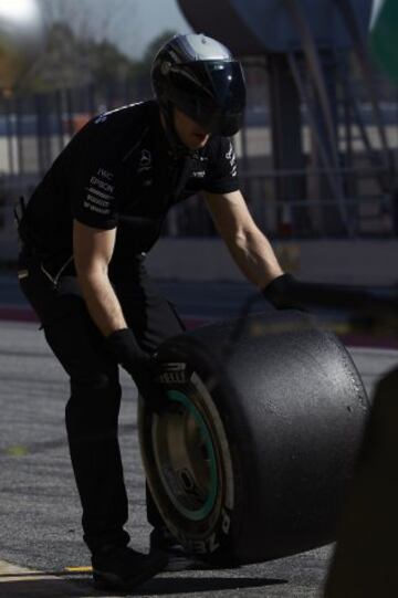 Un mecánico de Mercedes con uno de los nuevos neumáticos.