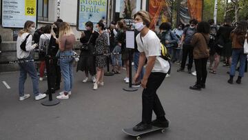 A man rides his skate along a queue of visitors for the Palais de Tokyo museum, wearing a protective face mask as a precaution against the coronavirus, in Paris, Saturday, Sept. 5, 2020. New French cases of COVID-19 jumped in 24 hours to nearly 9,000, health officials said Friday. The 8,975 new cases were the highest number of infections since France successfully grappled with the spread of the coronavirus during a strict two-month lockdown. There were some 1,800 cases less a day earlier and more than for European neighbors. (AP Photo/Francois Mori)