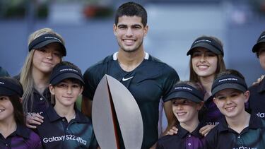 Tennis - ATP Masters 1000 - Madrid Open - Caja Magica, Madrid, Spain - May 8, 2022 Spain's Carlos Alcaraz Garfia poses with the trophy and the ball boys and girls after winning the final against Germany's Alexander Zverev REUTERS/Juan Medina