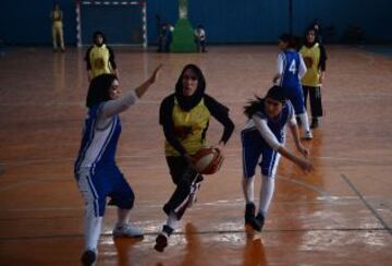 Las jugadoras de baloncesto afganas de la provincia de Herat (en amarillo) compiten con el equipo de Kabul, en un partido amistoso en el Estadio Olímpico Nacional de Kabul el 18 de septiembre de 2013.