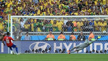 Brazil&#039;s goalkeeper Julio Cesar (R) dives to save a penalty kick by Chile&#039;s defender Gonzalo Jara during the penalty shootout after the extra time in the round of 16 football match between Brazil and Chile at The Mineirao Stadium in Belo Horizon