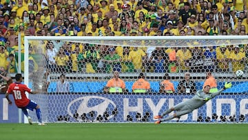 Brazil&#039;s goalkeeper Julio Cesar (R) dives to save a penalty kick by Chile&#039;s defender Gonzalo Jara during the penalty shootout after the extra time in the round of 16 football match between Brazil and Chile at The Mineirao Stadium in Belo Horizon