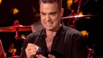 Robbie Williams se desintecta las manos despu&eacute;s de saludar a sus fans.