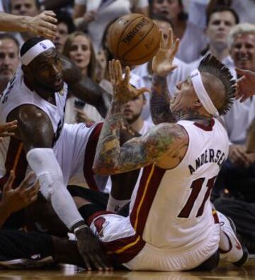 Miami Heat 95 (4) - San Antonio Spurs 88 (3). Chris Andresen y LeBron James luchan un balón desde el suelo.